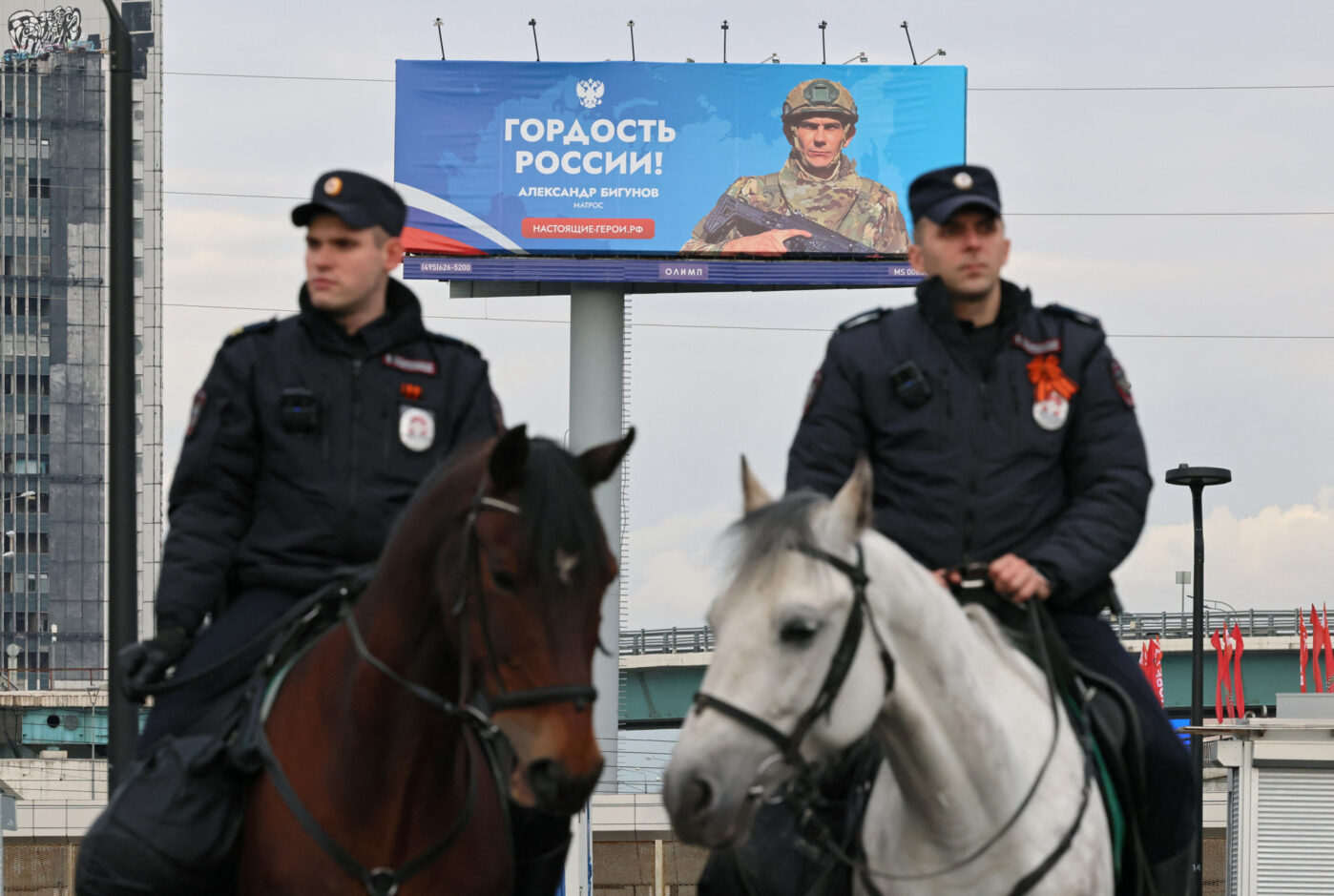 Конная полиция патрулирует улицу возле баннера с рекламой службы по контракту в Москве